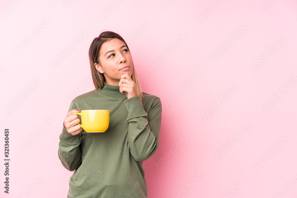 Young caucasian woman holding a coffee looking sideways with doubtful and skeptical expression. Young caucasian woman holding a coffee looking sideways with doubtful and skeptical expression.