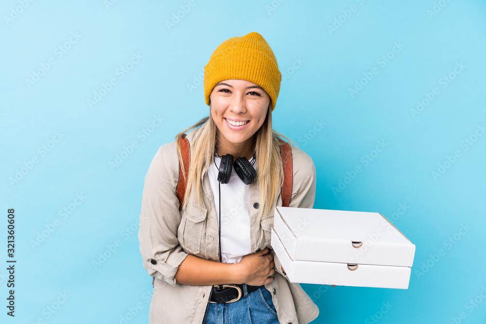 Young caucasian woman holding pizzas isolated laughing and having fun. Young caucasian woman holding pizzas isolated laughing and having fun.