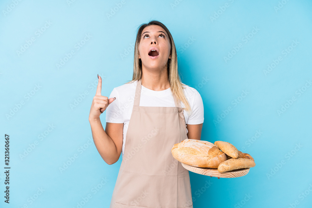 Young caucasian baker woman isolated pointing upside with opened mouth. Young caucasian baker woman isolated pointing upside with opened mouth.