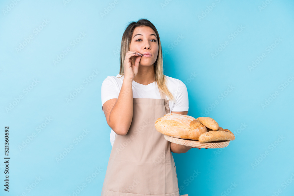 Young caucasian baker woman isolated with fingers on lips keeping a secret. Young caucasian baker woman isolated with fingers on lips keeping a secret.