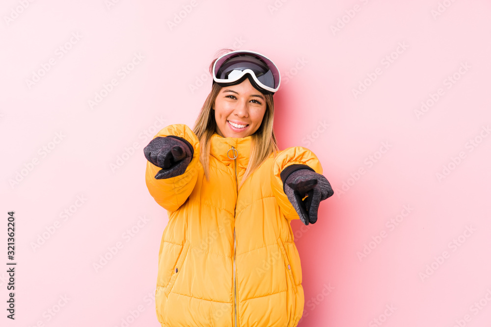 Young caucasian woman wearing a ski clothes in a pink background cheerful smiles pointing to front. Young caucasian woman wearing a ski clothes in a pink background cheerful smiles pointing to front.