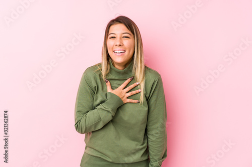 Young caucasian woman posing isolated  laughs out loudly keeping hand on chest. © Asier