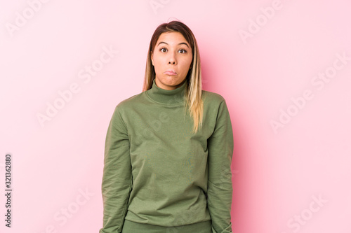 Young caucasian woman posing isolated  shrugs shoulders and open eyes confused. © Asier