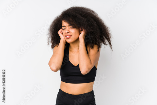 Young african american sporty woman covering ears with hands.