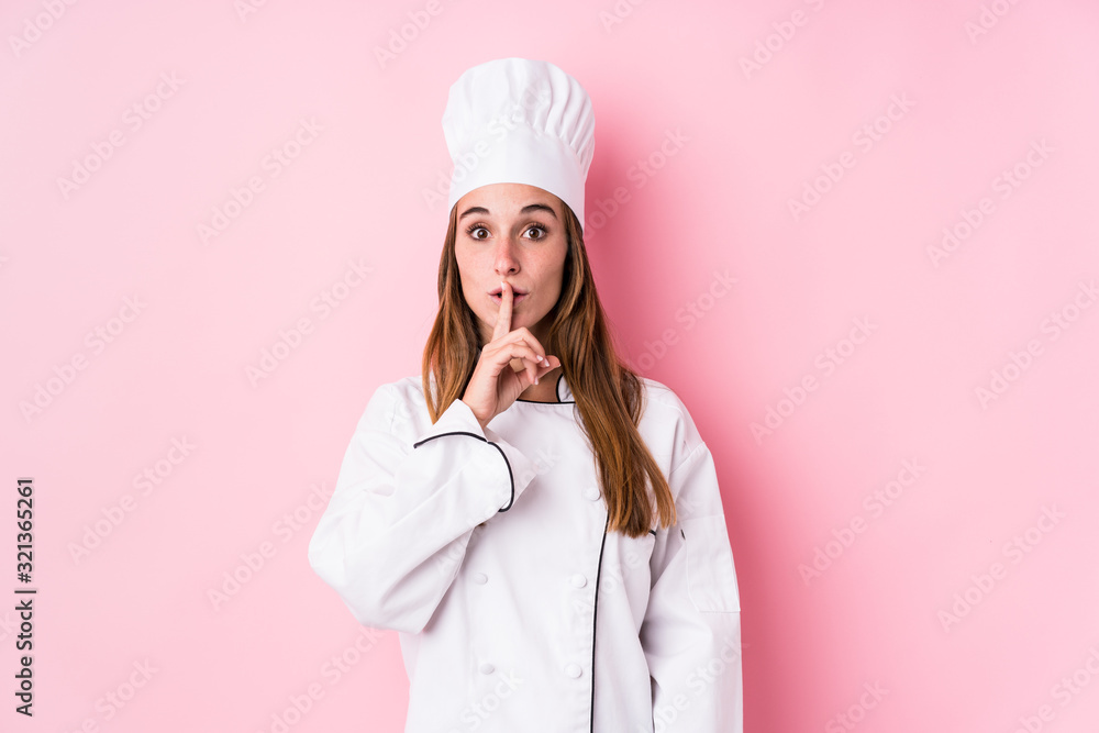 Young caucasian chef woman isolated keeping a secret or asking for silence. Young caucasian chef woman isolated keeping a secret or asking for silence.