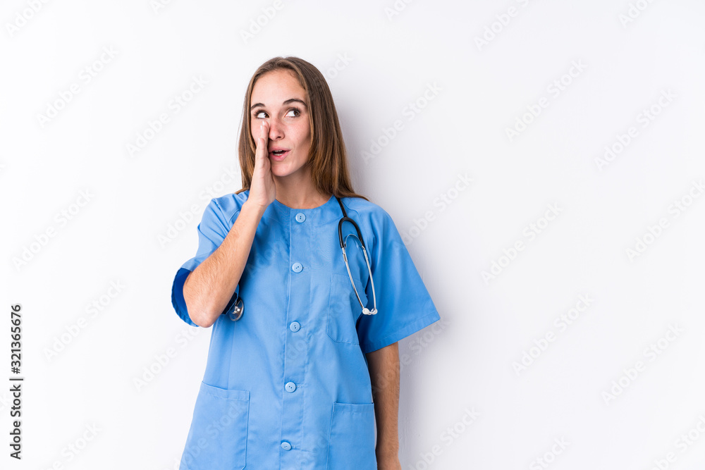 Young nurse woman isolated is saying a secret hot braking news and looking aside Young nurse woman isolated is saying a secret hot braking news and looking aside