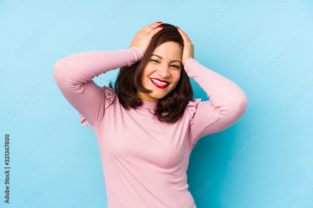 Middle age latin woman isolated laughs joyfully keeping hands on head. Happiness concept. Middle age latin woman isolated laughs joyfully keeping hands on head. Happiness concept.