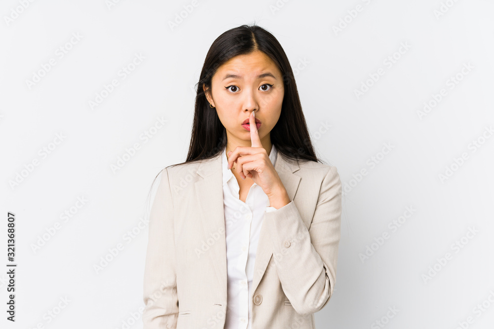 Young chinese business woman isolated keeping a secret or asking for silence. Young chinese business woman isolated keeping a secret or asking for silence.