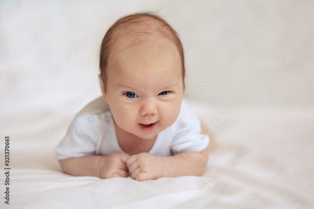 baby, newborn baby, cute blue-eyed, dark hair, baby 1 month, lying on a white bed