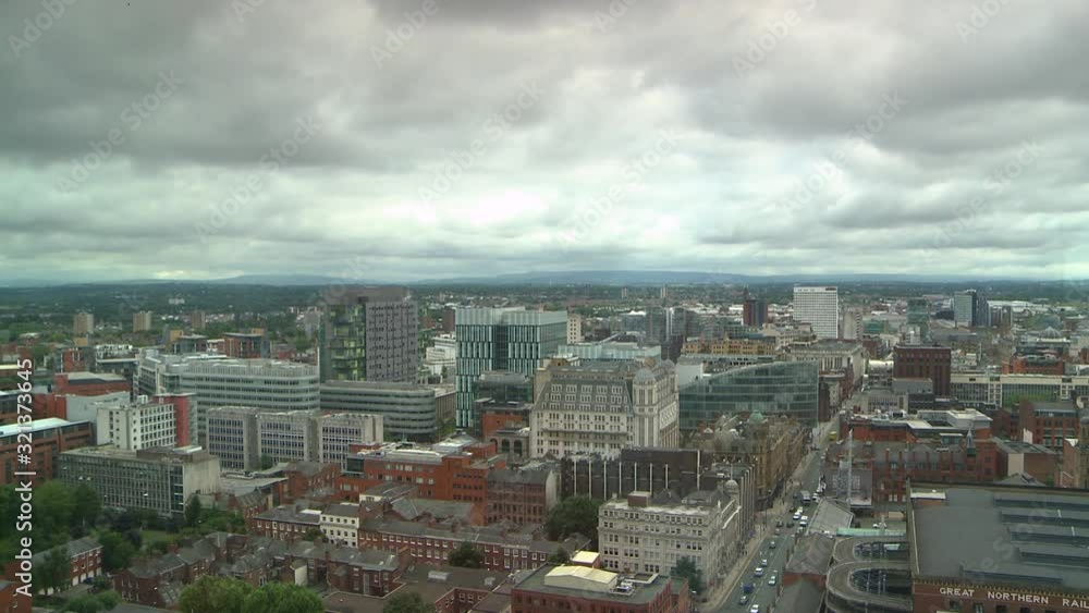 A wide panning shot of buildings with hills in the distant background on an overcast day A wide panning shot of buildings with hills in the distant background on an overcast day