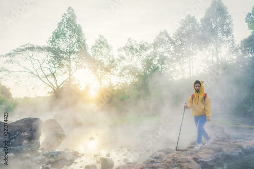 Blurry traveler and Morning fog over hot spring at Chae Son National Park, Thailand