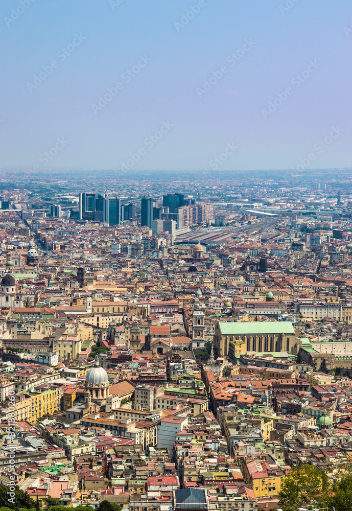 Aerial view of Naples in a hot summer day. Spaccanapoli, Naples Central Business District, Naples' train station (Napoli Centrale), and the Church of Santa Chiara are visible.