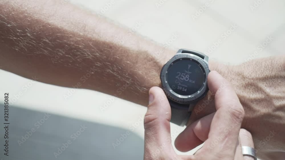 Man is adjusting the time on his wristwatch Man is adjusting the time on his wristwatch