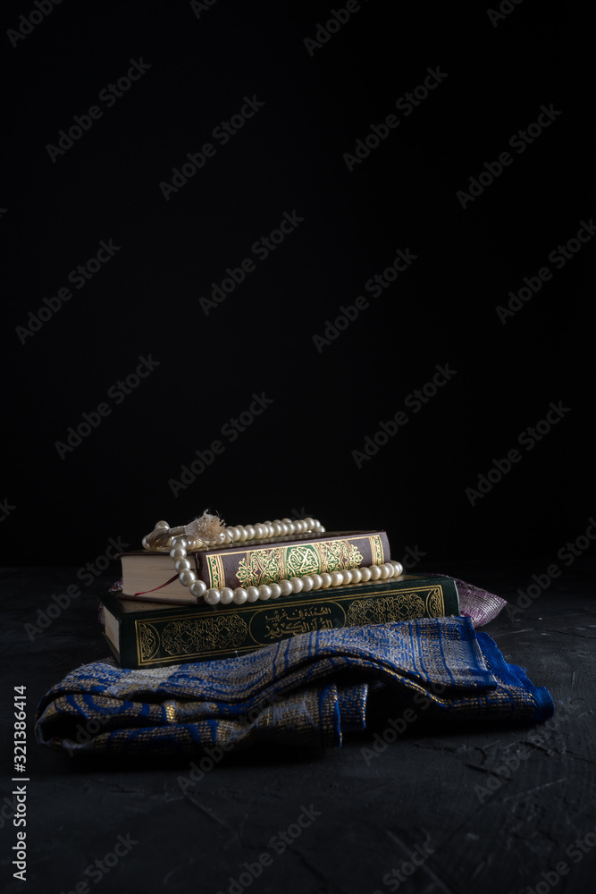 Faith in Islam, Holy book Islamic scripture al-Quran and rosary beads on dark background. Islamic holiday celebration Eid Mubarak or Ramadan Kareem concept. Faith in Islam, Holy book Islamic scripture al-Quran and rosary beads on dark background. Islamic holiday celebration Eid Mubarak or Ramadan Kareem concept.