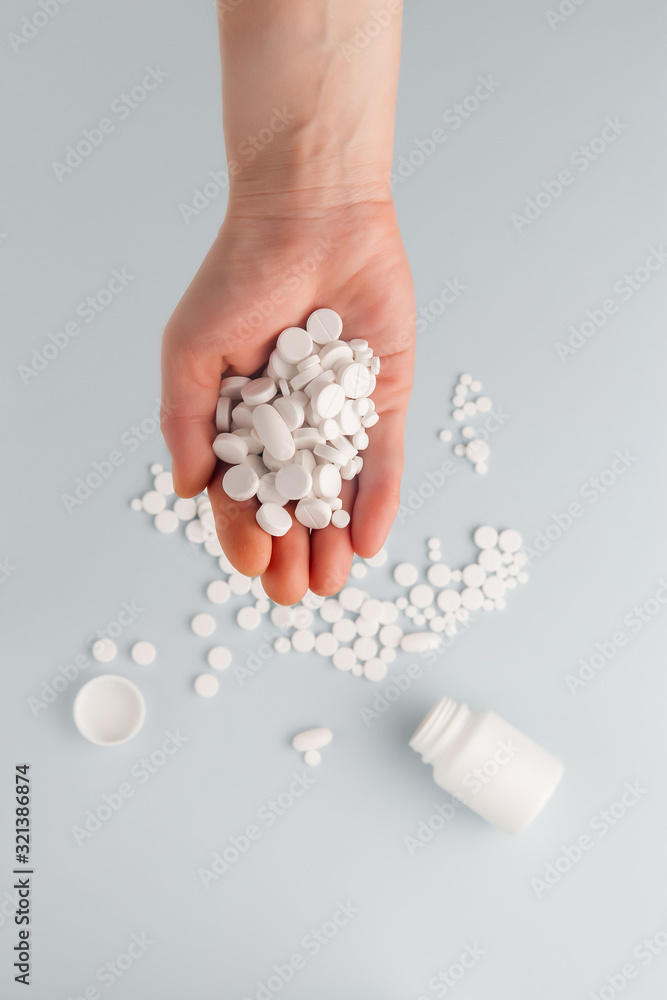 Round white pills on the palm of a female top view, overdose of pills. Copy space. Pharmacy and medical concept Round white pills on the palm of a female top view, overdose of pills. Copy space. Pharmacy and medical concept