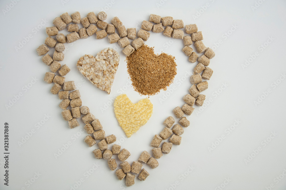 health heart made from pressed bran, rice briquette, ground bran on a white background health heart made from pressed bran, rice briquette, ground bran on a white background