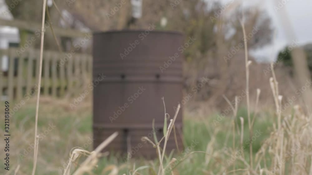 Rusty oil drum abandoned in a field defocused Rusty oil drum abandoned in a field defocused