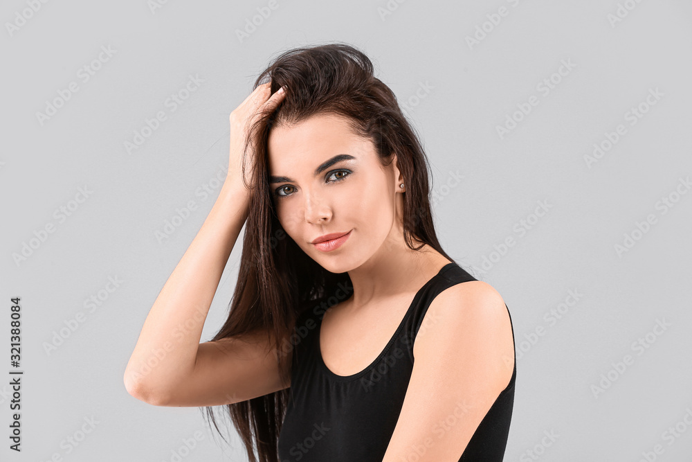 Beautiful fashionable young woman on grey background Beautiful fashionable young woman on grey background