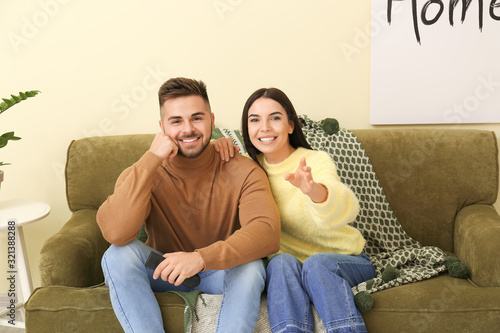 Young couple watching TV wh...