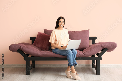 Young woman with laptop sit...