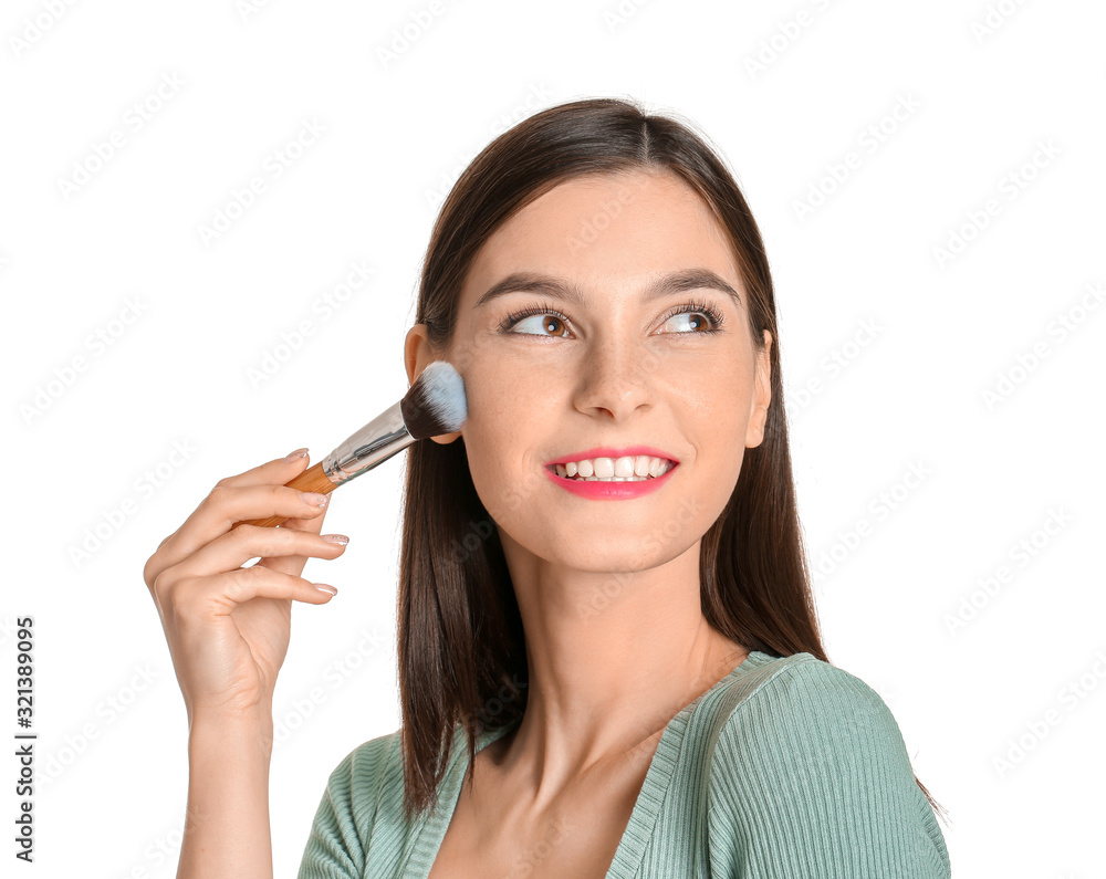 Beautiful young woman applying makeup on white background Beautiful young woman applying makeup on white background