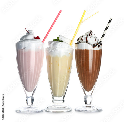 Glasses of tasty milkshakes on white background