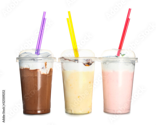 Cups of tasty milkshakes on white background