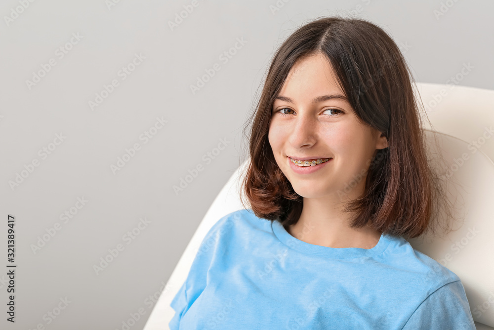 Teenage girl with dental braces sitting in dentist's armchair Teenage girl with dental braces sitting in dentist's armchair