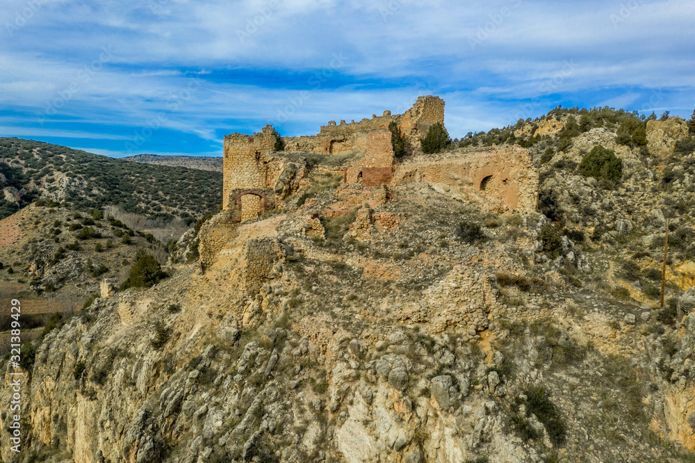 Aerial view of Santa Croche (Saint Cross) medieval castle ruin on the road to Albarracin Spain on a steep crag with a semi circular donjon and partially ruined embrasure 