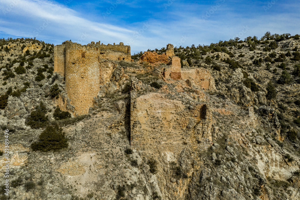 Aerial view of Santa Croche (Saint Cross) medieval castle ruin on the road to Albarracin Spain on a steep crag with a semi circular donjon and partially ruined embrasure 