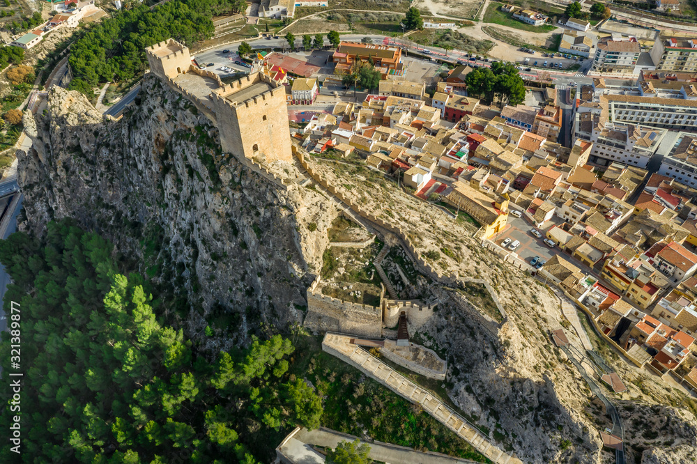 Aerial view of medieval restored Sax castle with two rectangular towers and two semi circular towers protecting the gate near Alicante Spain