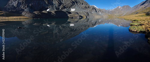 Picturesque mountain lake on a sunny morning. Beautiful reflection, panoramic view. Summer rest.