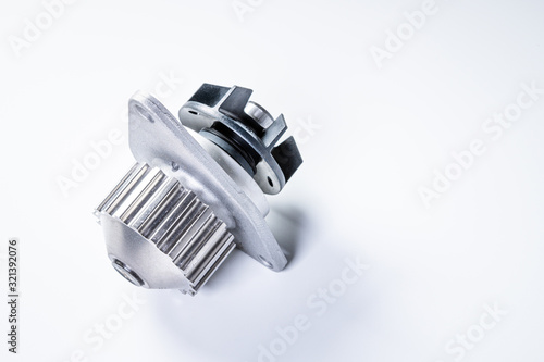 Fototapeta Naklejka Na Ścianę i Meble -  New metal automobile pump for cooling the engine of a water pump on a gray background. The concept of new spare parts for the car engine