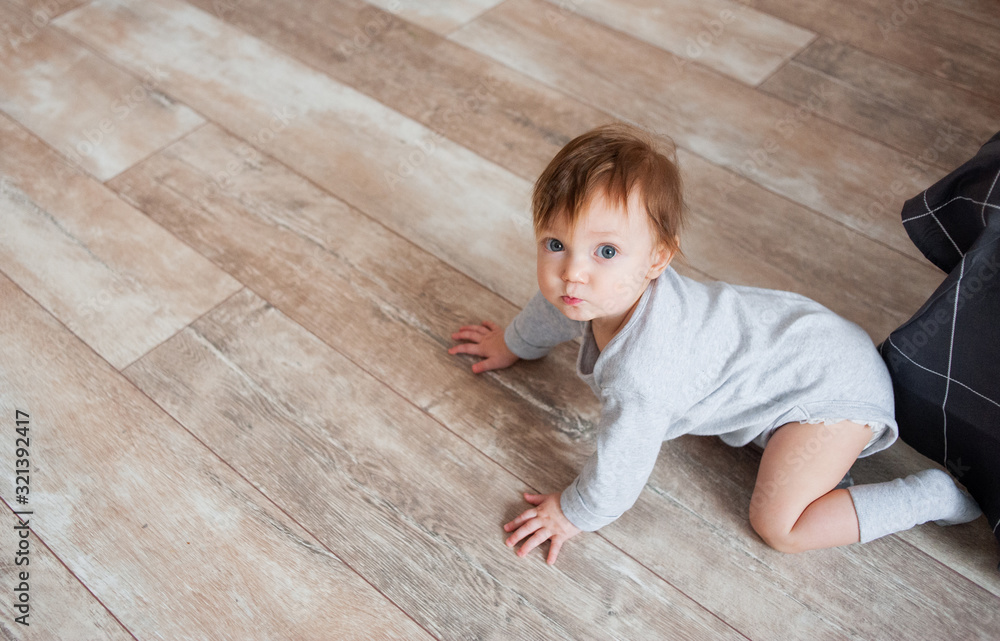 Little cute girl crawls on floor and looks at camera. Little cute girl crawls on floor and looks at camera.