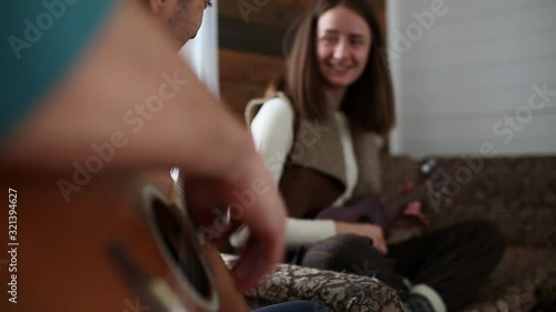 Couple plays guitar and ukulele in a country house