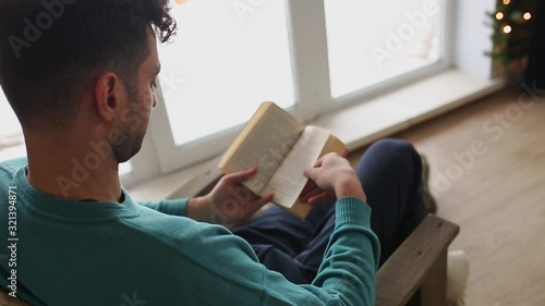 A man read a book sitting in a chair