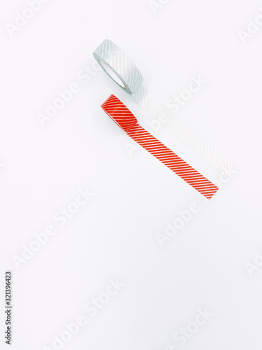 Isolated top view of straps paper tape in red and silver grey sticking on surface with white background and copy space.