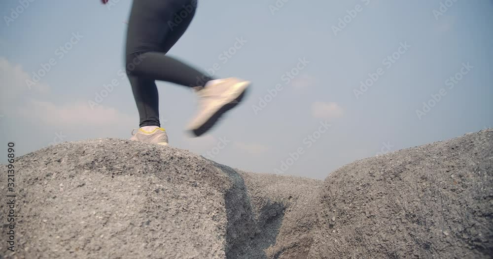 SLOW MOTION, Close up Trail running in the rock mountain rubble high jumping, Athlete fit woman exercise runners professional outdoor difficult and challenging healthy people lifestyle SLOW MOTION, Close up Trail running in the rock mountain rubble high jumping, Athlete fit woman exercise runners professional outdoor difficult and challenging healthy people lifestyle