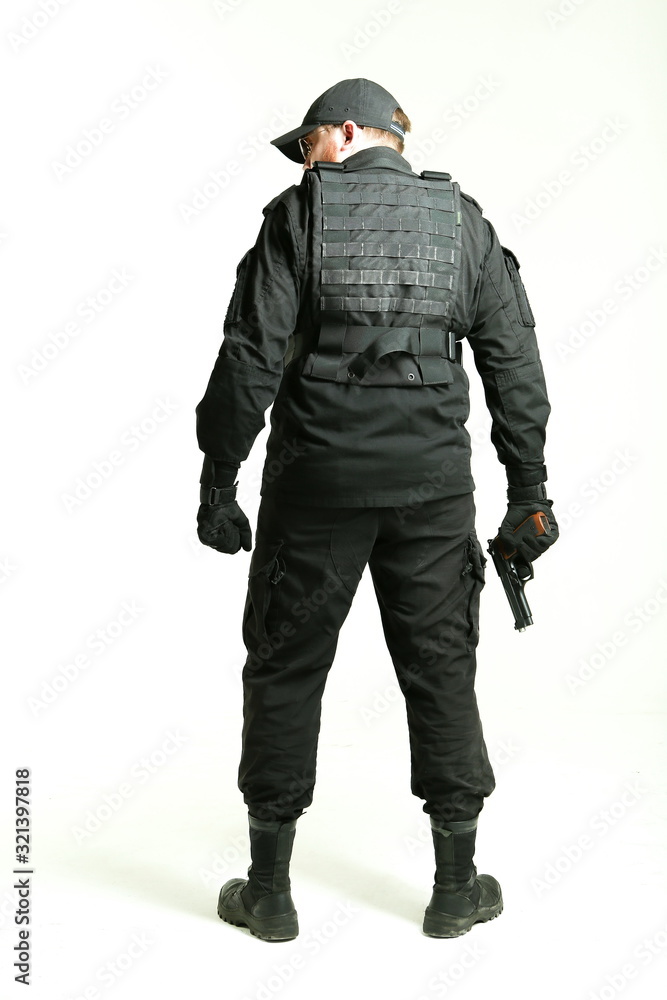 man in a black military uniform holding gun and standing with his back ...
