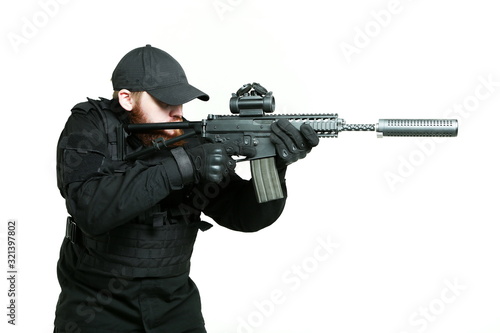 man in a black military uniform aiming with machine gun on white background 