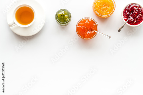 Fruit jam near tea on white kitchen desk frame copy space