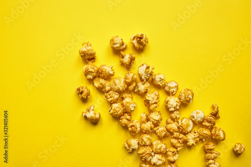 Popcorn with caramel on bright yellow background