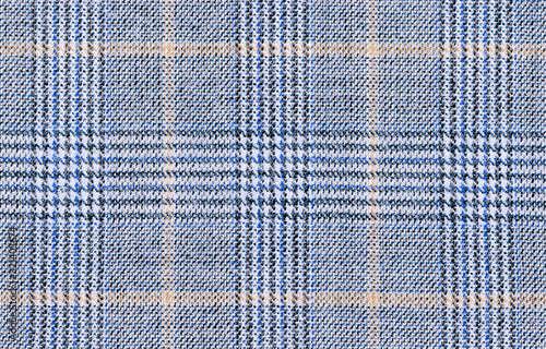 Beige Glenurquhart check is made of blue woolen fabric. Classic  Wool Background Texture. Coat close-up. Expensive men's suit