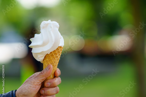 Hand holding ice cream cone. Vanilla ice cream