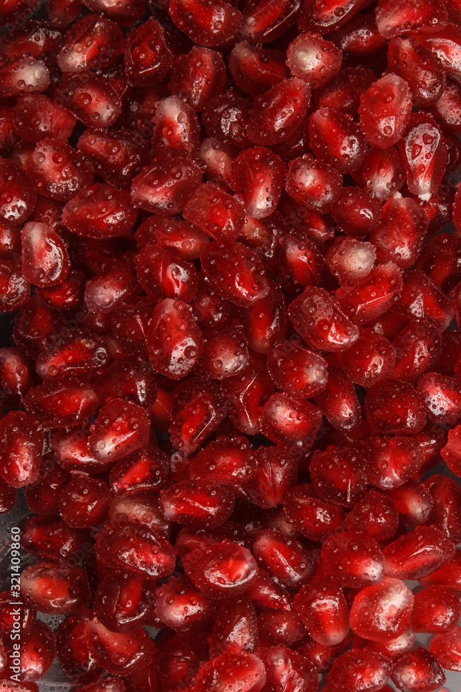 Pomegranate seeds with water drops. Texture for the background. Ripe berries of pomegranate. Red texture of the granules in the macro. Pomegranate seeds with water drops. Texture for the background. Ripe berries of pomegranate. Red texture of the granules in the macro.