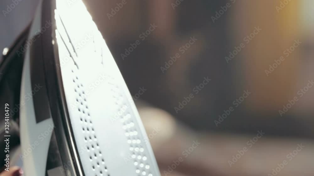 Iron with steam and water stream close-up. Ironing clothes on ironing board. Iron with steam and water stream close-up. Ironing clothes on ironing board.