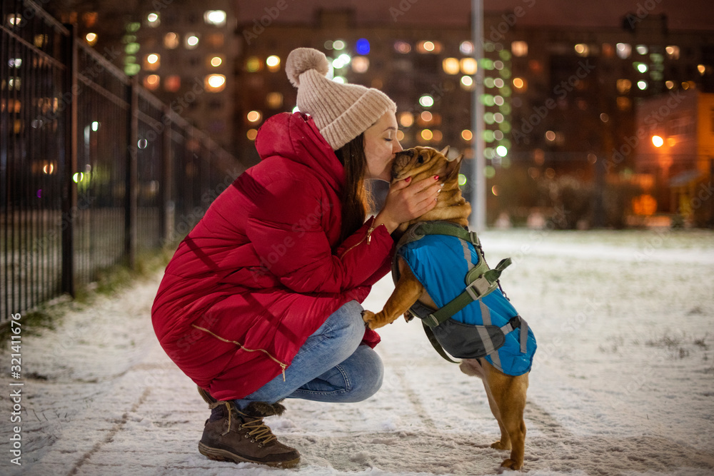 young girl walks on a winter evening with her dog