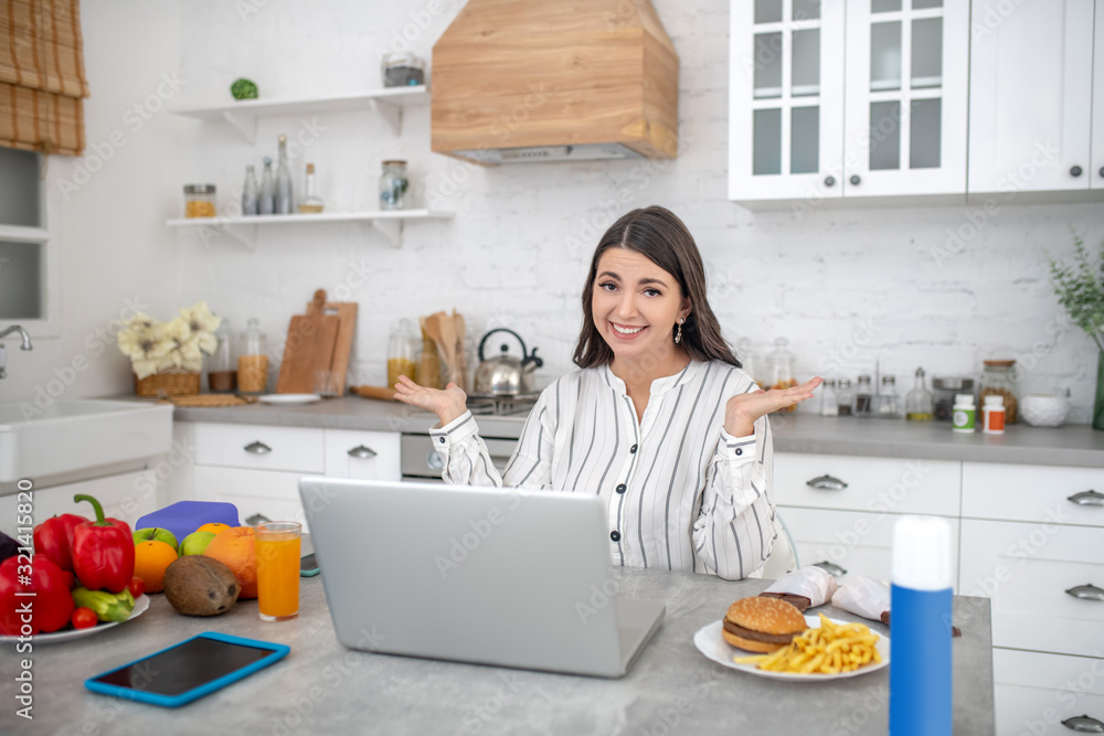 Dark-haired woman in a striped blouse thinking about food Dark-haired woman in a striped blouse thinking about food