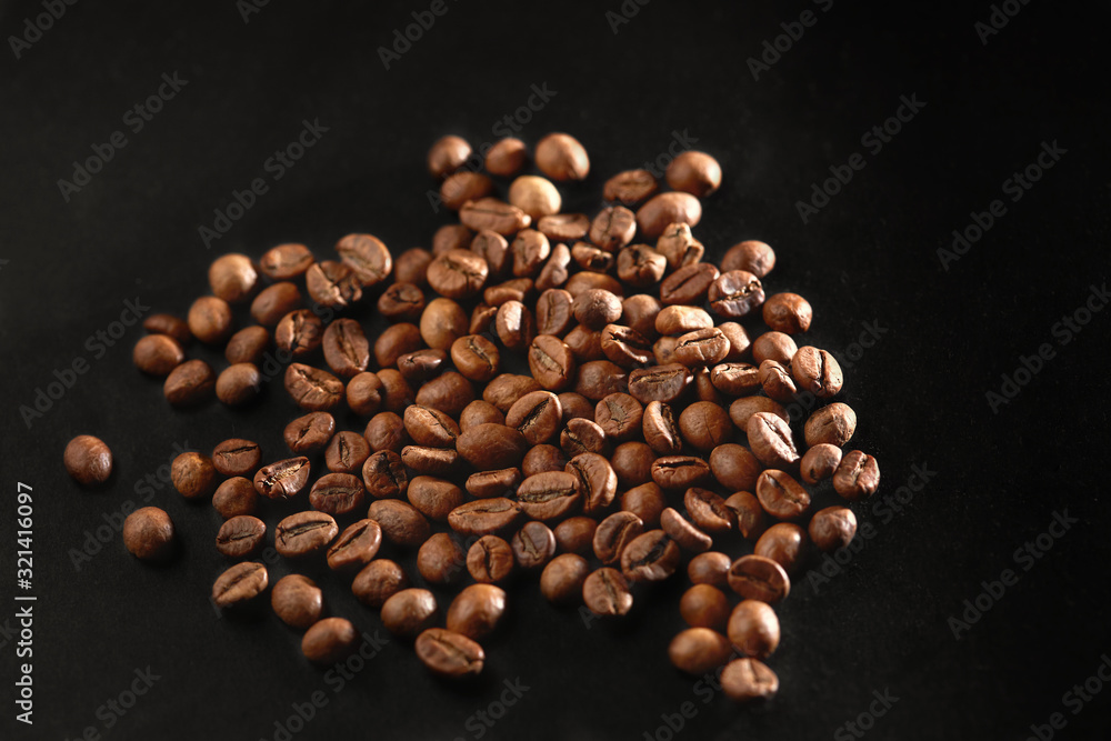 Brown roasted coffee beans on dark background. Espresso dark, aroma, black caffeine drink. Closeup isolated energy mocha, cappuccino ingredient. Brown roasted coffee beans on dark background. Espresso dark, aroma, black caffeine drink. Closeup isolated energy mocha, cappuccino ingredient.