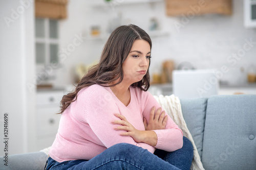 Fotografie Full-figured young woman in a pink shirt feeling depressed
